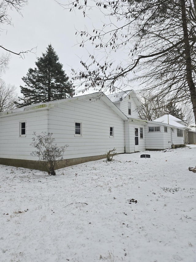 view of snow covered back of property