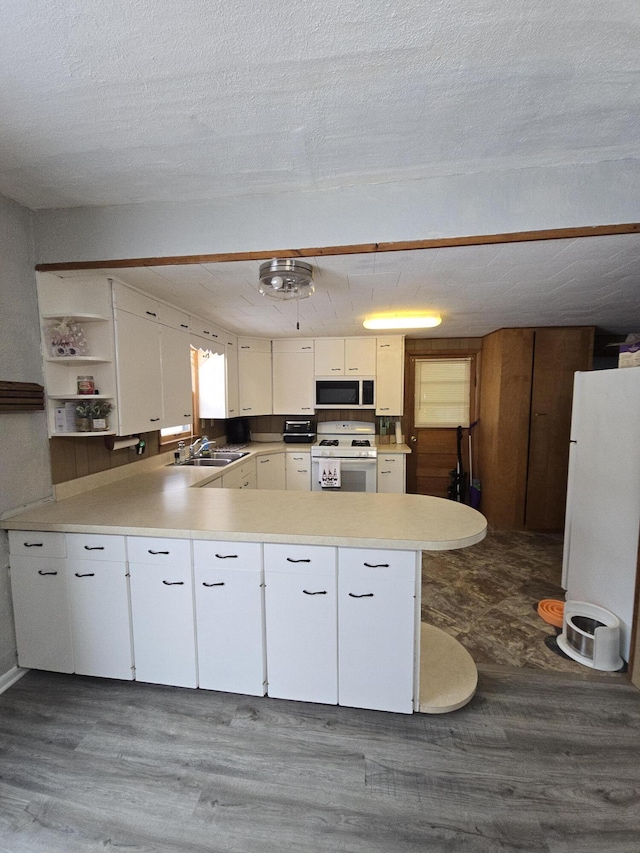 kitchen featuring a textured ceiling, white cabinetry, dark hardwood / wood-style flooring, and white appliances