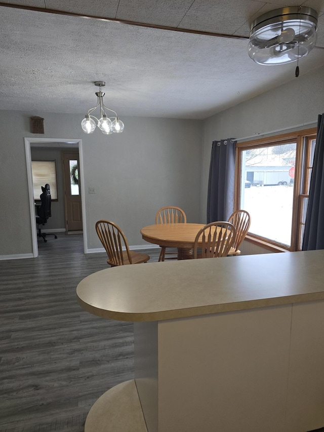 dining space featuring a textured ceiling, a chandelier, and dark hardwood / wood-style floors