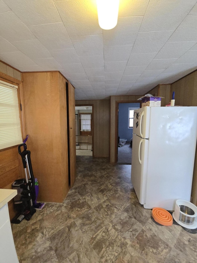 kitchen with wood walls and white fridge