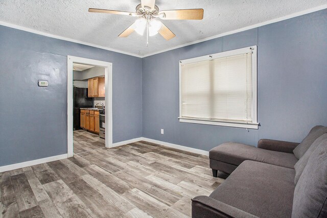 living area featuring a textured ceiling, light hardwood / wood-style floors, and ceiling fan