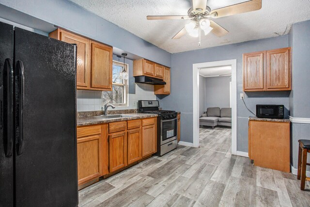 kitchen featuring ceiling fan, sink, light hardwood / wood-style flooring, a textured ceiling, and black appliances