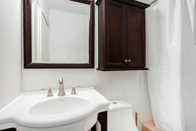 full bathroom featuring sink, tasteful backsplash, toilet, shower / tub combo with curtain, and tile walls