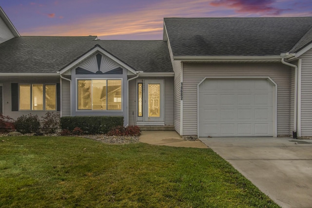 view of front of home with a yard and a garage