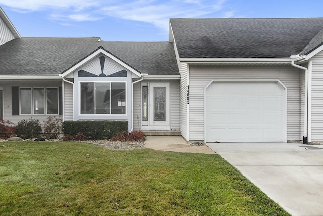 ranch-style house featuring a garage and a front lawn