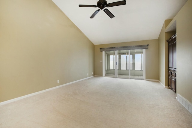 carpeted empty room featuring ceiling fan and vaulted ceiling