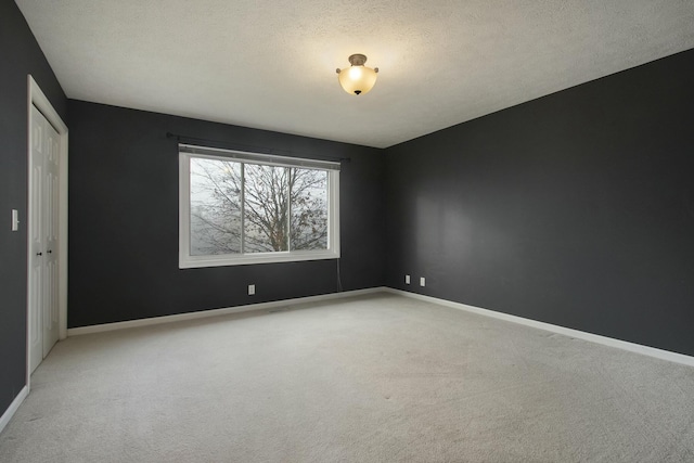 carpeted spare room featuring a textured ceiling