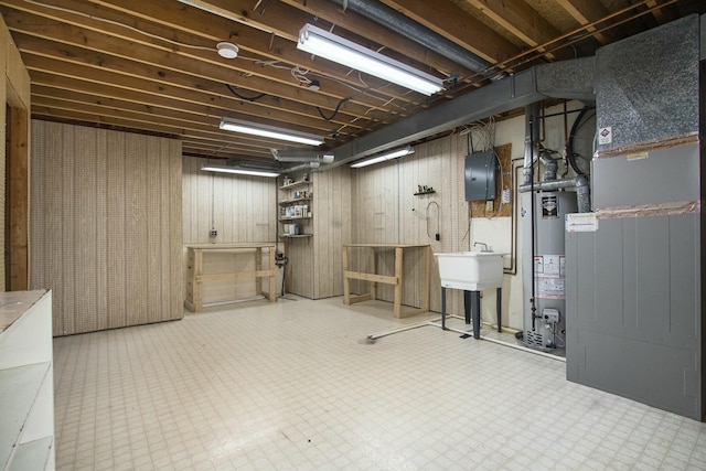 basement featuring wood walls and water heater