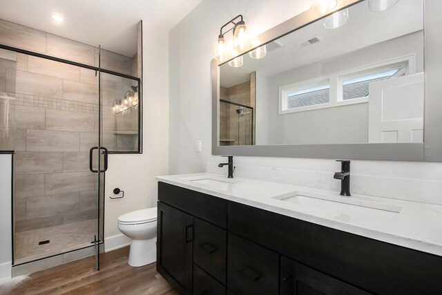 bathroom with vanity, wood-type flooring, an enclosed shower, and toilet