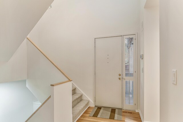 foyer entrance featuring stairway and light wood-style flooring