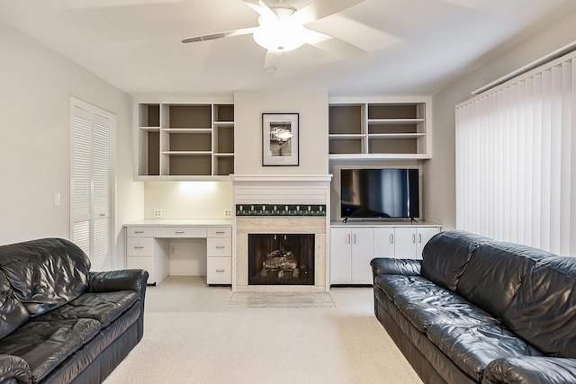 living room with light colored carpet, ceiling fan, and built in shelves
