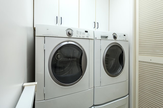laundry area featuring washing machine and dryer and cabinet space