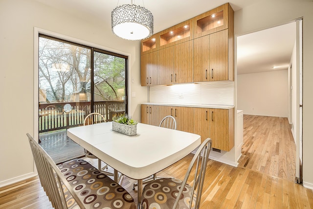dining room with baseboards and light wood-type flooring