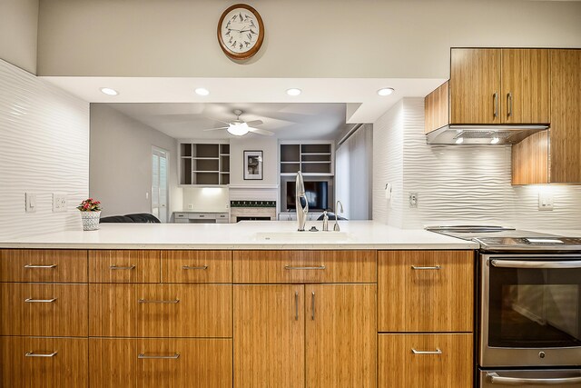 kitchen featuring backsplash, a ceiling fan, light countertops, under cabinet range hood, and electric stove