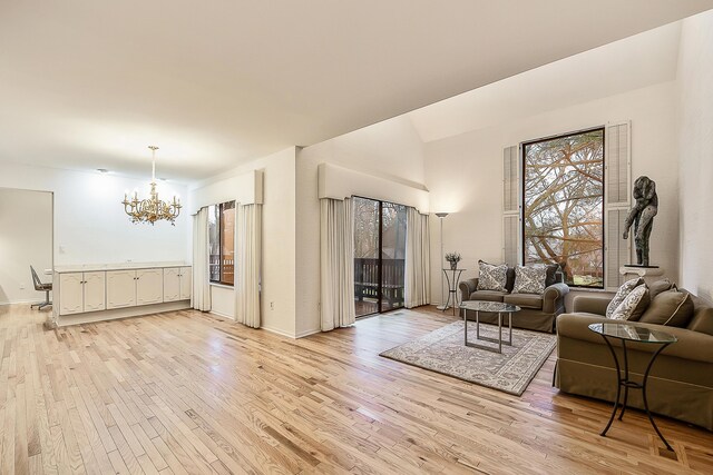 living room featuring a chandelier, light wood-style flooring, and baseboards