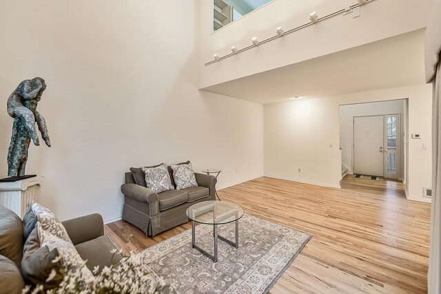 living room featuring visible vents, baseboards, and wood finished floors