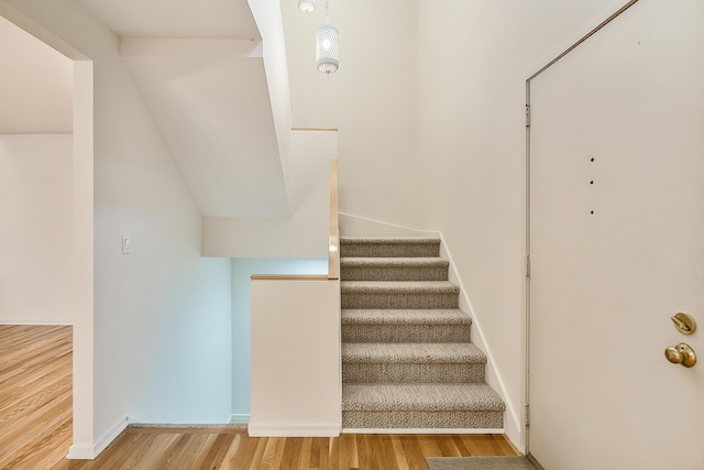 staircase featuring baseboards and wood finished floors