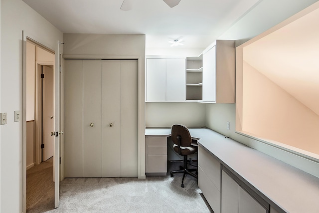office with light carpet, built in desk, and ceiling fan