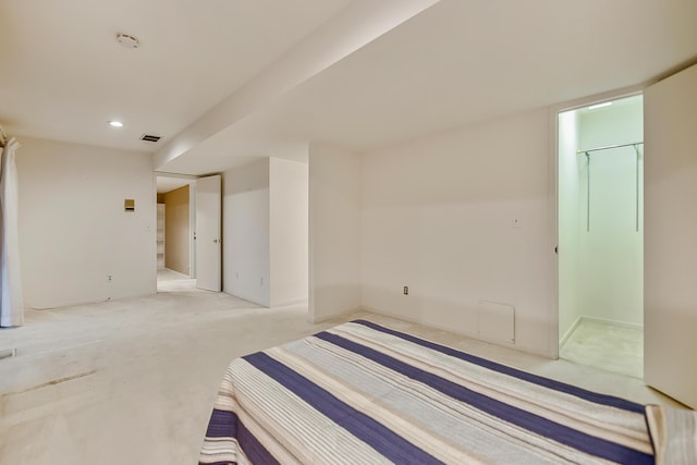 unfurnished bedroom featuring a closet, a spacious closet, light carpet, visible vents, and recessed lighting