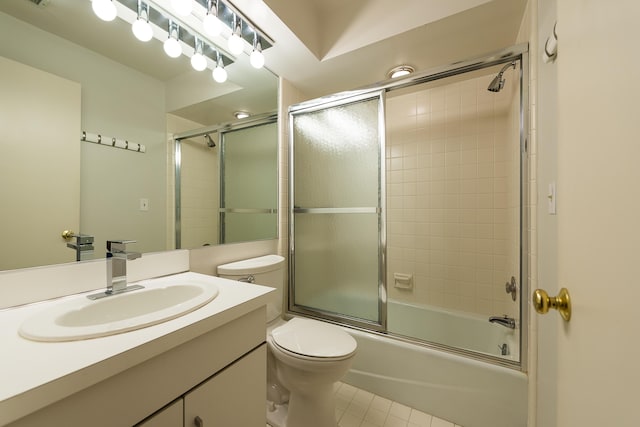bathroom with vanity, tile patterned flooring, bath / shower combo with glass door, and toilet