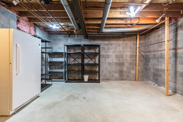 unfinished below grade area with freestanding refrigerator
