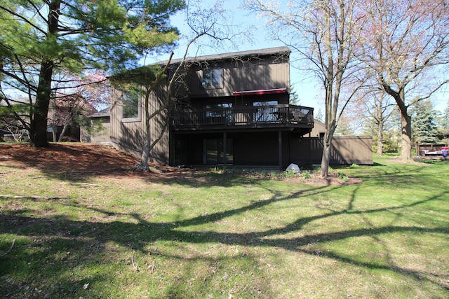 rear view of property featuring a lawn and a deck
