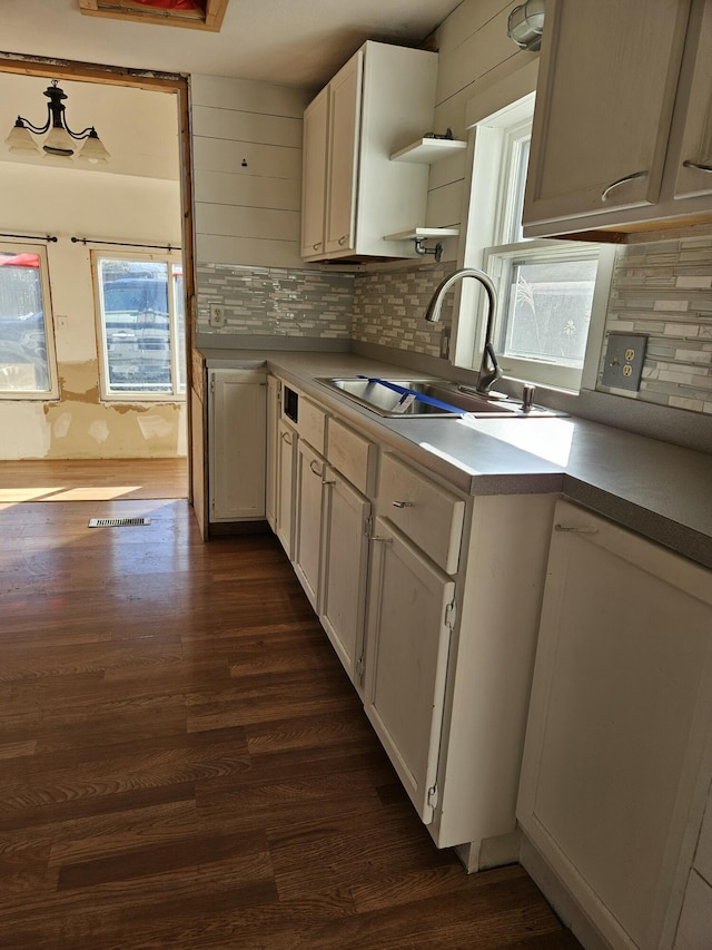 kitchen with white cabinets, backsplash, dark wood-type flooring, and sink