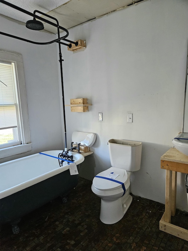 bathroom featuring a washtub and toilet