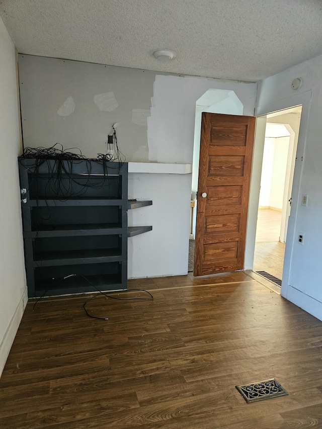 entryway with dark hardwood / wood-style floors and a textured ceiling