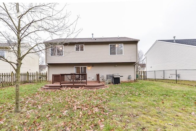 rear view of house featuring a yard and a deck