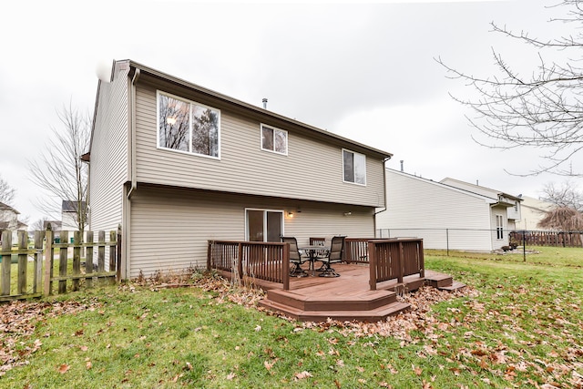 back of house featuring a lawn and a wooden deck