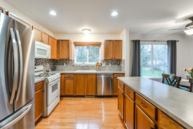 kitchen with stainless steel appliances, plenty of natural light, light hardwood / wood-style floors, and sink