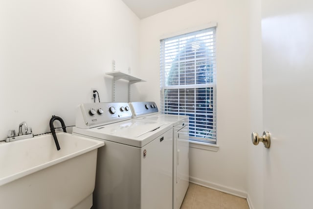 clothes washing area featuring independent washer and dryer, light tile patterned floors, and sink