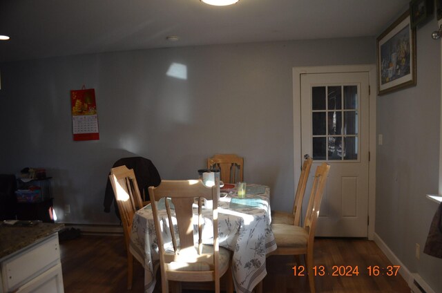 dining area with dark hardwood / wood-style flooring and a baseboard heating unit