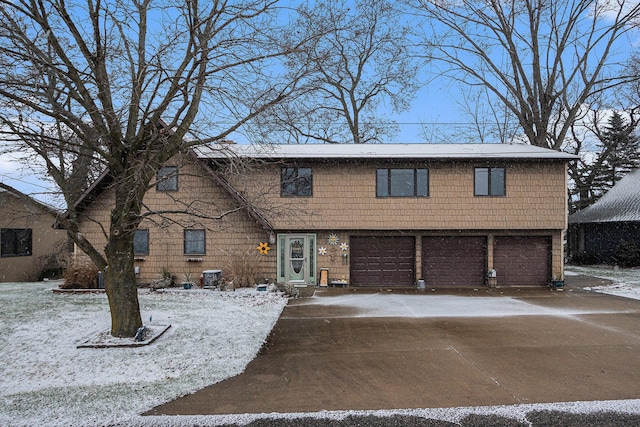 view of front of property featuring central AC and a garage