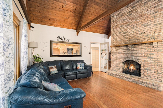 living room featuring wooden ceiling, lofted ceiling with beams, wood-type flooring, and a brick fireplace