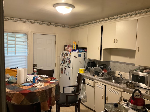 kitchen featuring white cabinets, white refrigerator, and sink