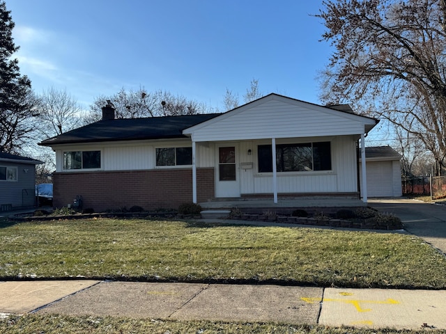 view of front of house featuring covered porch, a garage, and a front lawn