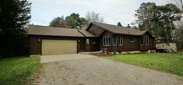 view of front of house featuring a garage, a front lawn, and a wooden deck