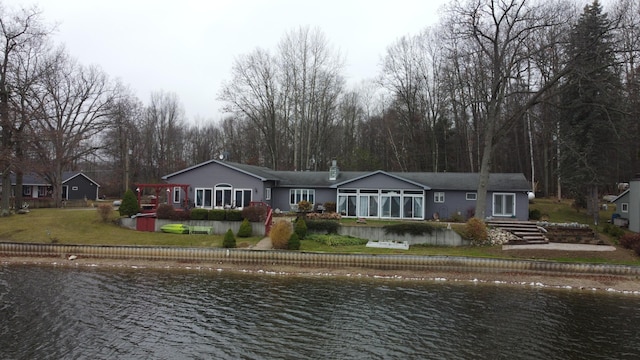 back of house featuring a yard and a water view