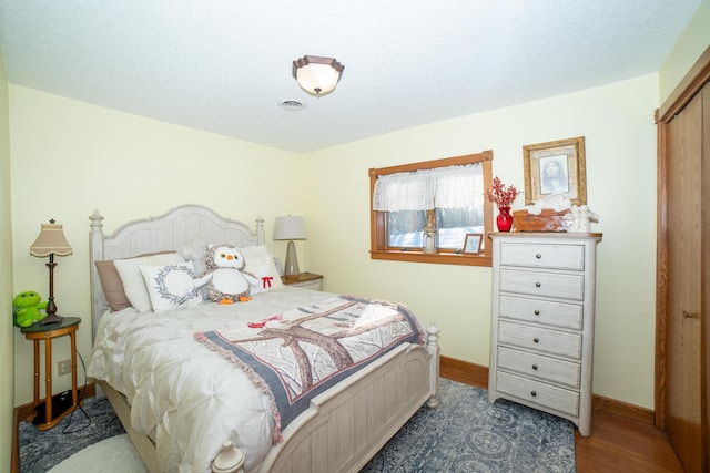 bedroom with a closet and dark hardwood / wood-style floors