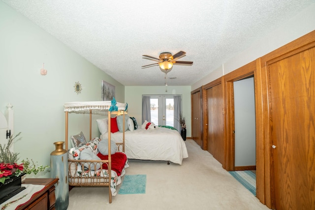 carpeted bedroom featuring french doors, a textured ceiling, and ceiling fan