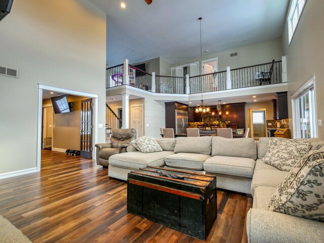 living room featuring a high ceiling, dark hardwood / wood-style flooring, and a notable chandelier