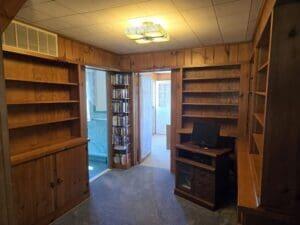 carpeted office featuring wood walls