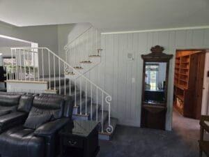 staircase with carpet flooring, crown molding, and wood walls