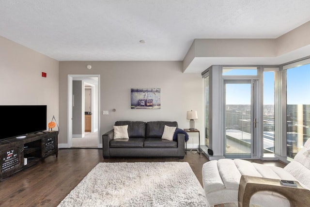 living room featuring a textured ceiling and dark hardwood / wood-style floors