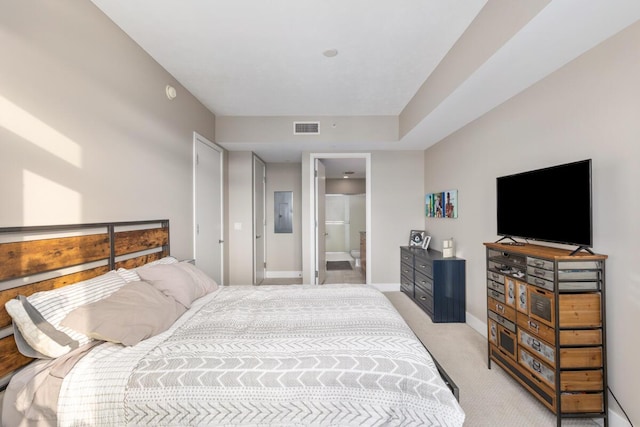 carpeted bedroom featuring electric panel and ensuite bath