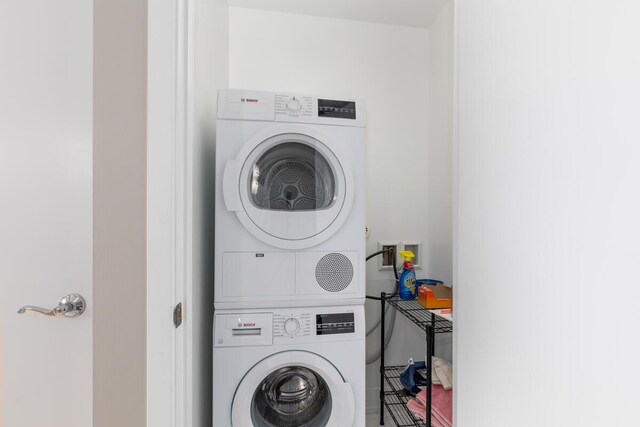 washroom featuring stacked washer / drying machine