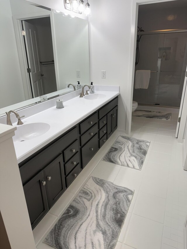 bathroom with tile patterned floors, toilet, vanity, and walk in shower