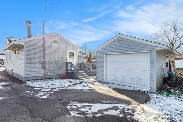 exterior space featuring a garage and an outbuilding